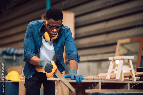 African american carpenter man working in wood factory, small business wood workshop. Timber industry and furniture factory.