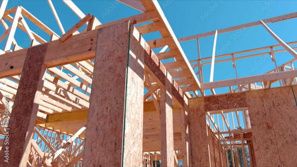 New under construction of timber truss framed building with rafters roof beams wooden joists construction framework New under construction of timber truss framed building with rafters roof beams wooden joists construction framework
