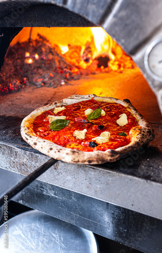 Wallpaper Mural Pizzaiolo pulls out a freshly baked Neapolitan Margherita Pizza from traditional wood-fired oven. Torontodigital.ca