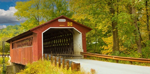 Silk Road covered bridge with trees showing fall colors near Paper Mill Village, Vermont. photo