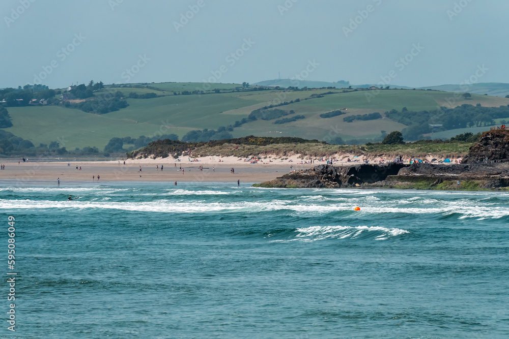 The Irish are relaxing on the seashore near Clonakilty on a summer day. Inchydoney beach, sea.