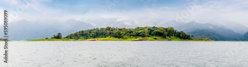 A panorama view across the Arenal Lake  towards the cloud covered volcano in Costa Rica during the dry season