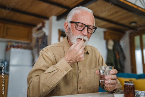 senior man caucasian grandfather take drug tablet drink painkillers
