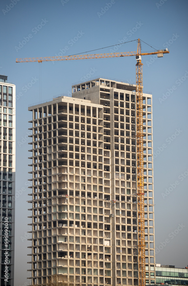 The structure of multi-storey buildings, tower cranes against the blue sky. The structure of multi-storey buildings, tower cranes against the blue sky.
