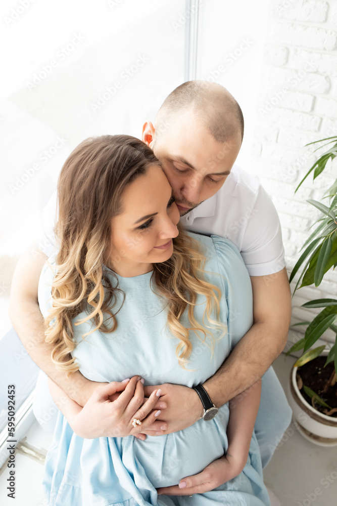 close-up portrait of embracing spouses. man hugging his pregnant wife close-up portrait. man kissing pregnant wife top view. beautiful angle close-up portrait of embracing spouses. man hugging his pregnant wife close-up portrait. man kissing pregnant wife top view. beautiful angle