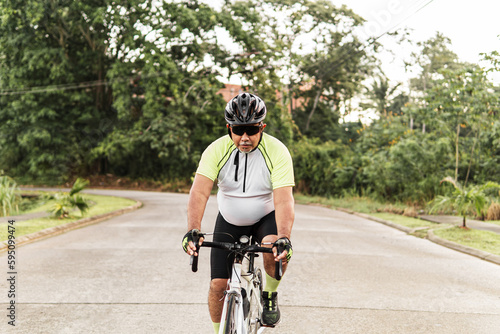 Cyclist man pedaling on a road bike outdoor in the morning.