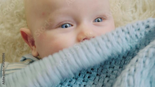 Adorable baby boy with blue eyes smiling and giggling in the room