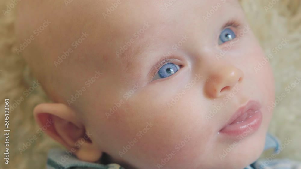 Adorable baby boy with blue eyes smiling and giggling in the room Adorable baby boy with blue eyes smiling and giggling in the room