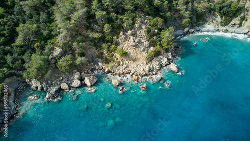 A breathtaking aerial view of a peaceful turquoise sea, lush greenery and crystal blue water at the beach. Turkish mediterranean sea.