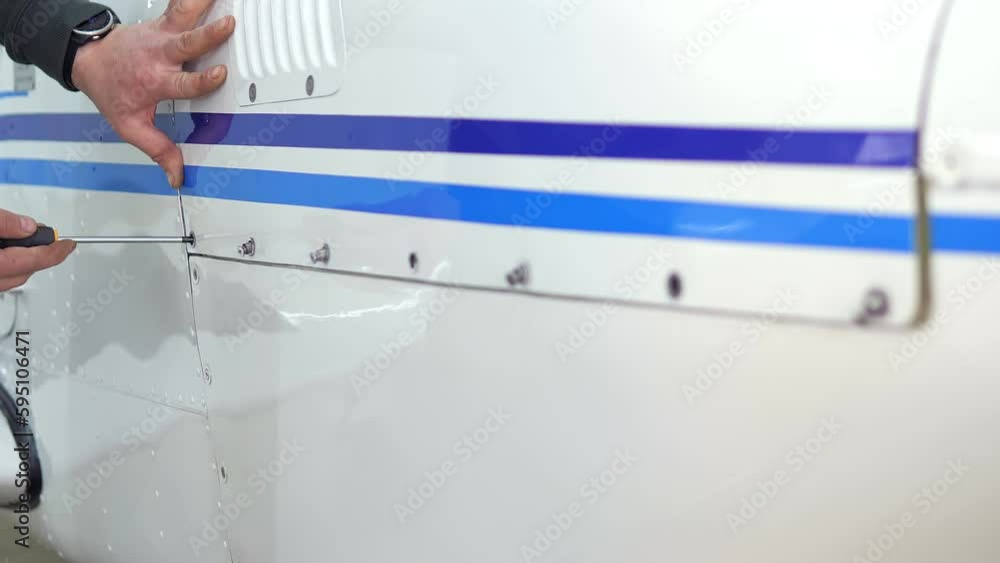 Closeup video of man's hands are taking screwdriver and fixing airplane