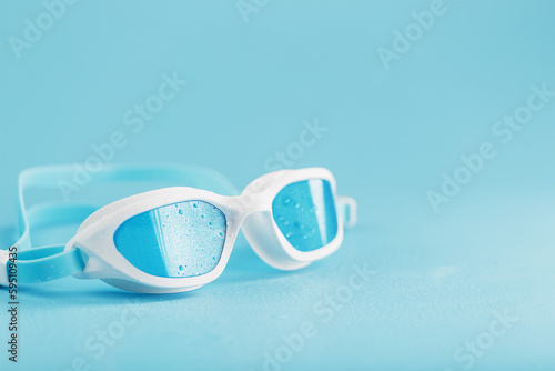 White swimming glasses with a blue lens