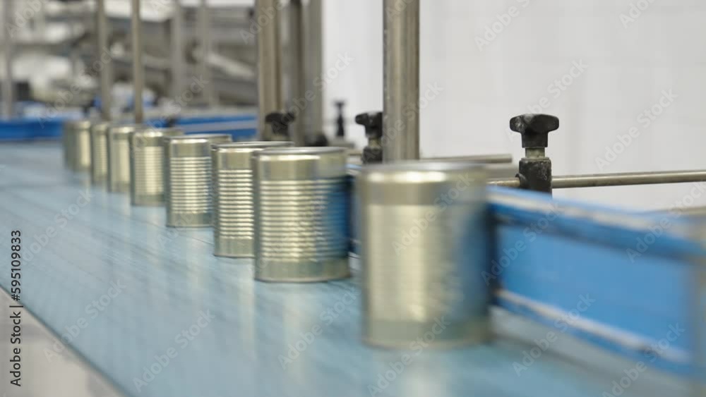 Green peas in cans on a conveyor belt in a canned food production facility Green peas in cans on a conveyor belt in a canned food production facility