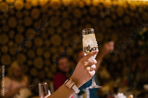 Bride raises a glass decorated with rhinestones at a wedding © ksyusha_yanovich