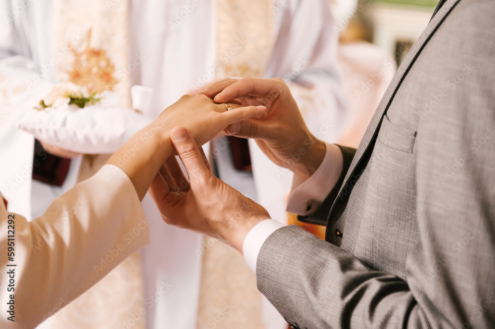 Obraz premium The bride and groom exchange rings in the church, the sacrament of the wedding