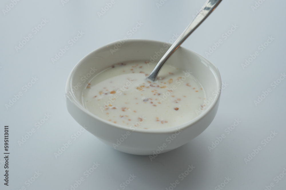 oats, banana and milk in a bowl on black background oats, banana and milk in a bowl on black background
