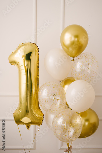 Composition of helium balloons white,, transparent with confetti, as well and a large figure of one golden colors. Gift for 1 years