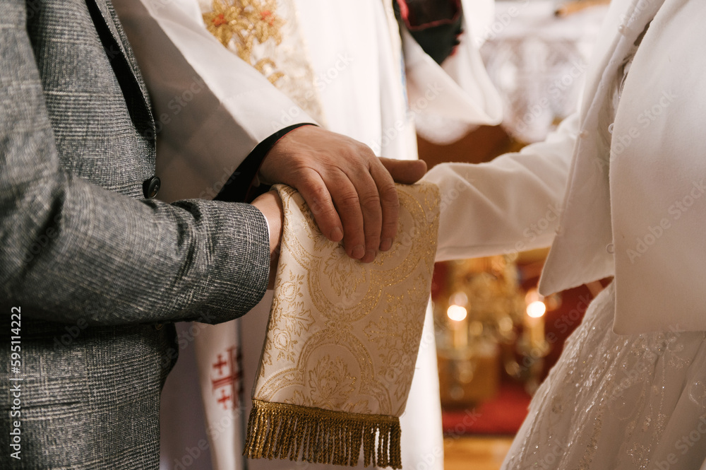 Obraz premium The bride and groom exchange rings in the church, the sacrament of the wedding