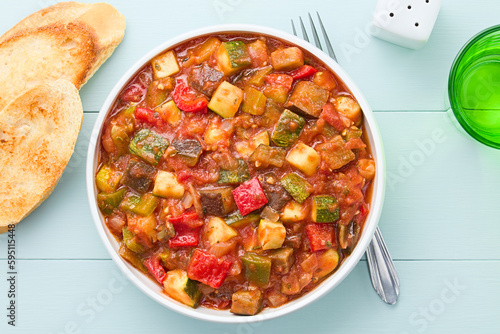 Fresh Ratatouille, a traditional French vegan vegetable stew made of eggplant, zucchini, bell pepper, tomato and onion with herbs, photographed overhead (Selective Focus, Focus on the dish) photo