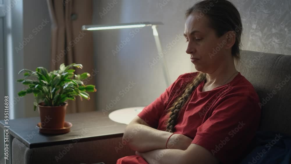Depressed sad woman sitting on sofa at home Depressed sad woman sitting on sofa at home