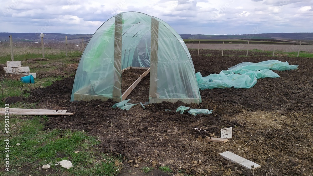 Construction of a homemade greenhouse made of boards, fittings and polyethylene