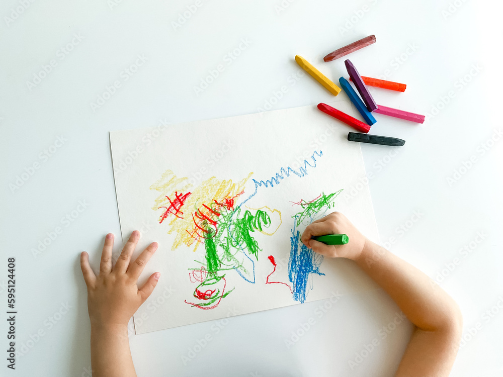 small child draws with pastel crayons on white table. fathers day small child draws with pastel crayons on white table. fathers day