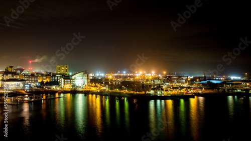 city skyline at night reflected in bay