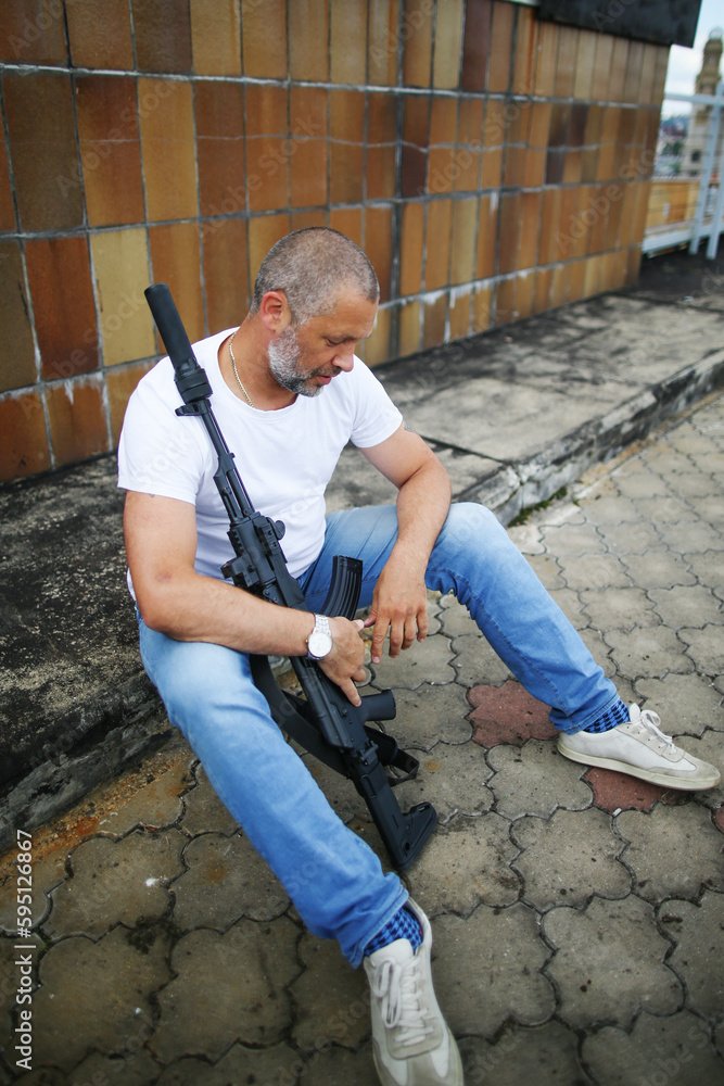 Fototapeta premium Rifleman sitting with a gun in hands