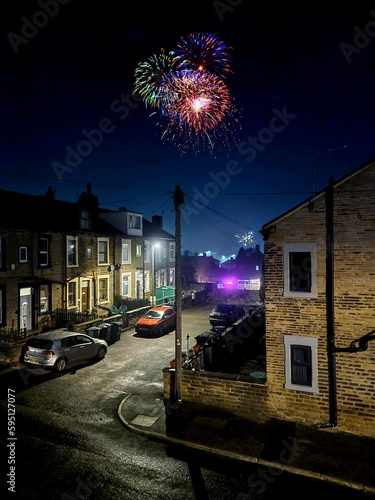 Fireworks in the night sky. Creative image done with 02 different exposures of night urban houses and fire works