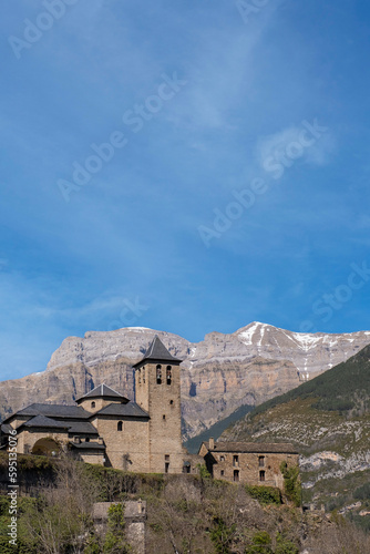 Torla, typical pyrenean village with stone houses with the mountains in the background, gateway to the Ordesa and Monte Perdido National Park in the Spanish Pyrenees, Aragon, Spain, vertical