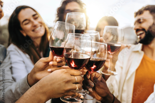 Young people toasting red wine glasses at farm house vineyard countryside - Happy friends enjoying happy hour at winery bar restaurant 
