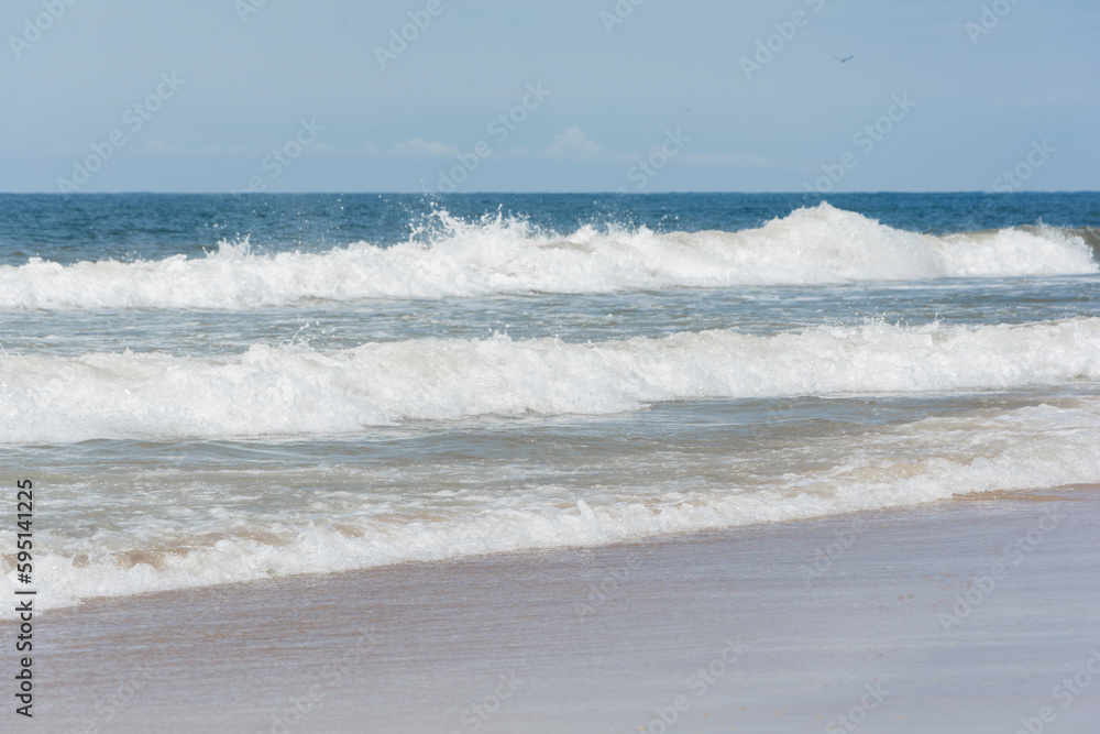 Waves breaking on the shore at the beach