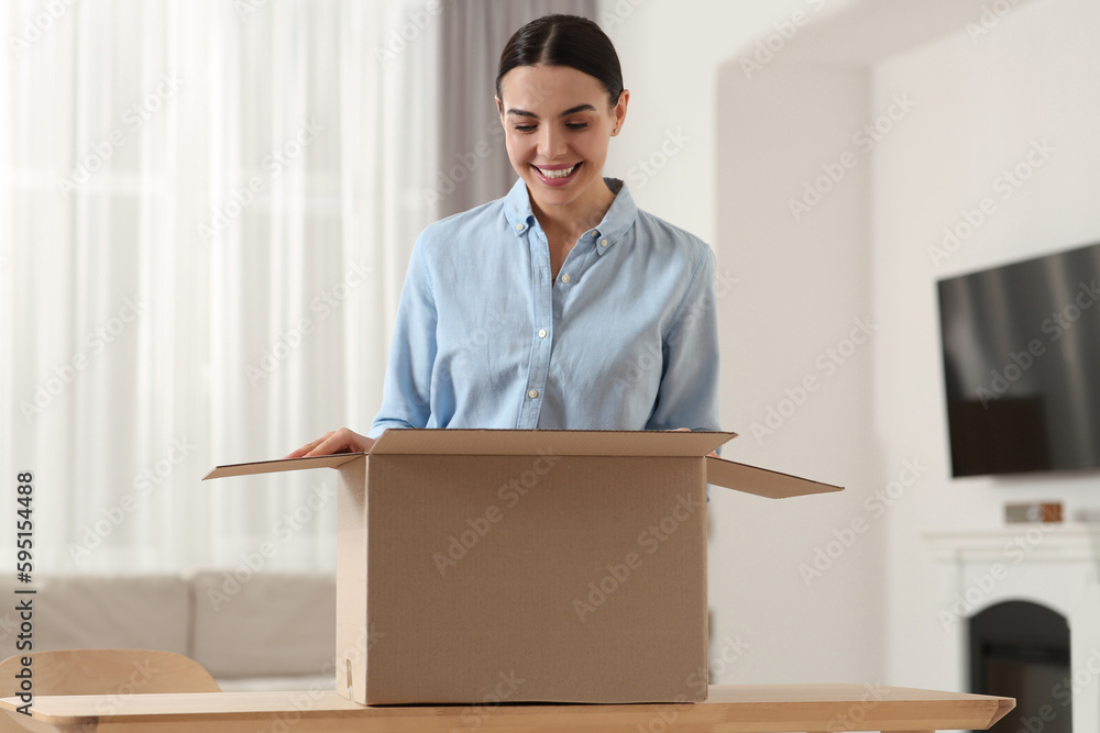 Happy young woman with opened parcel at home. Internet shopping Happy young woman with opened parcel at home. Internet shopping