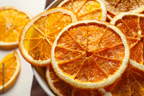 Many dry orange slices on white wooden table, closeup