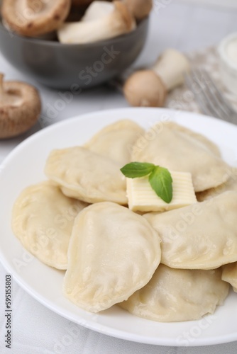 Delicious dumplings (varenyky) with tasty filling and butter on white table, closeup