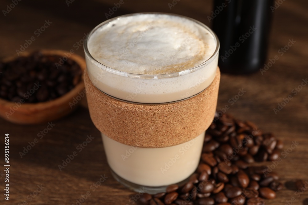 Bottle of delicious syrup, glass of coffee and beans on wooden table, closeup Bottle of delicious syrup, glass of coffee and beans on wooden table, closeup