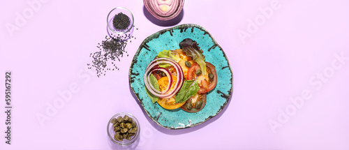 Plate with tasty tomato carpaccio on lilac background