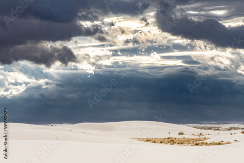 USA, New Mexico, White Sands National Monument. Sunrise storm clouds over white desert sand.