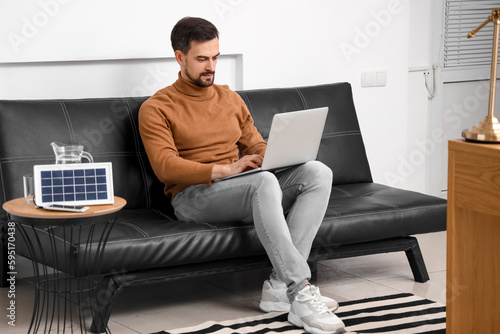 Handsome man using laptop n...