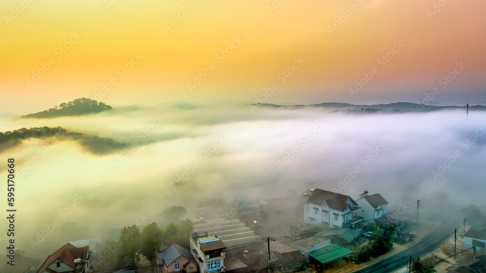 Fototapeta premium Aerial view of Xuan Tho suburbs near Da Lat city at morning with misty and sunrise sky. This place is considered most beautiful and peaceful place to watch sunrise in highlands of Vietnam