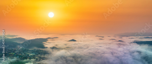 Fototapeta Naklejka Na Ścianę i Meble -  Aerial view of Xuan Tho suburbs near Da Lat city at morning with misty and sunrise sky. This place is considered most beautiful and peaceful place to watch sunrise in highlands of Vietnam