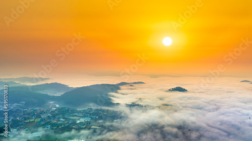 Aerial view of Xuan Tho suburbs near Da Lat city at morning with misty and sunrise sky. This place is considered most beautiful and peaceful place to watch sunrise in highlands of Vietnam © huythoai