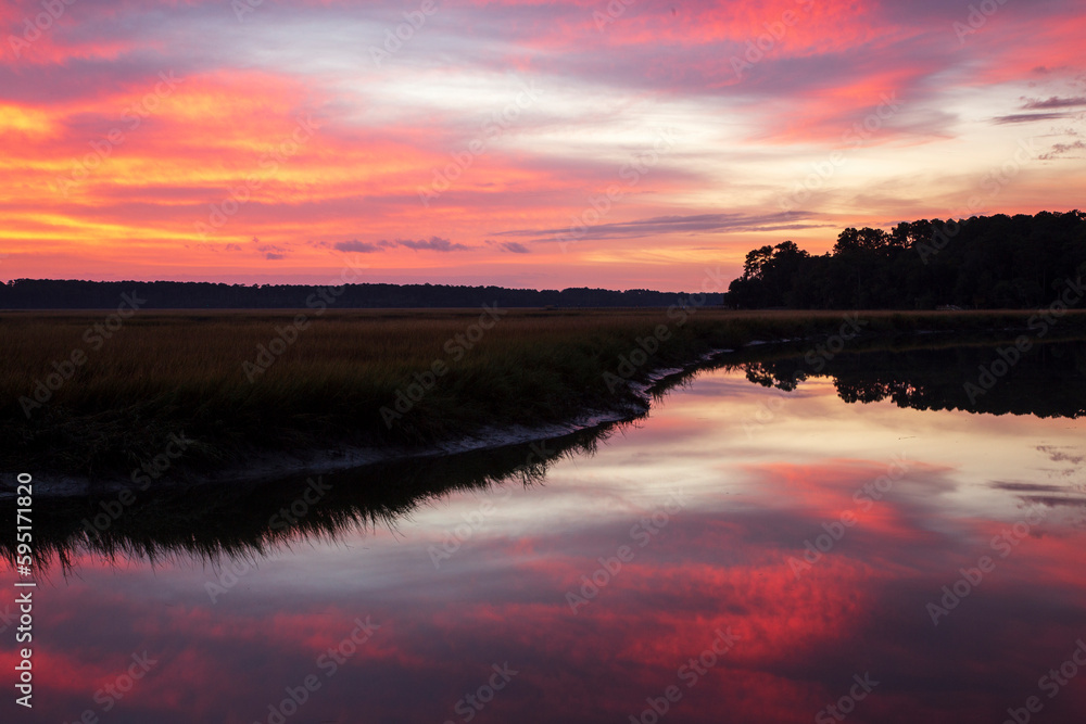 USA, Georgia. Sunrise reflections in marsh at Grimball Point.