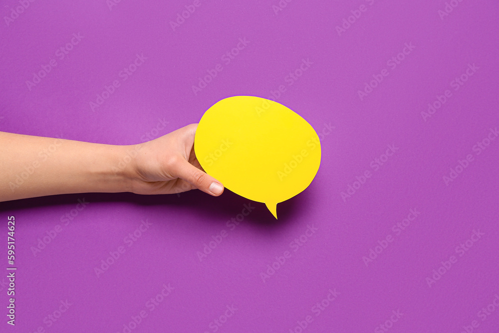 Woman holding blank speech bubble on purple background Woman holding blank speech bubble on purple background