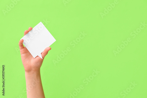 Woman holding blank speech bubble on green background