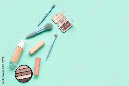 Decorative cosmetics with brushes on mint background