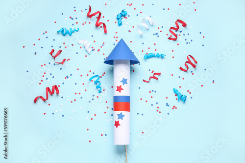 Fotografija Firework rocket, confetti and serpentine for Independence Day on blue background