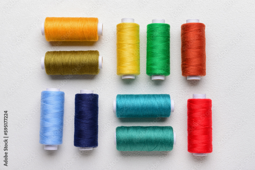 Composition with colorful thread spools on light background Composition with colorful thread spools on light background