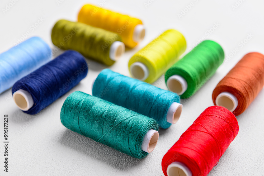 Composition with colorful thread spools on light background, closeup Composition with colorful thread spools on light background, closeup