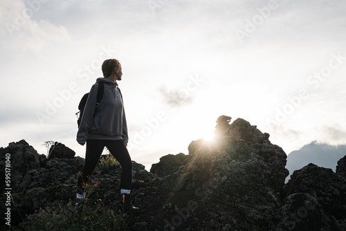 Hiker Exploring Rocky Terrain at Sunset in a Tranquil Outdoor Setting.