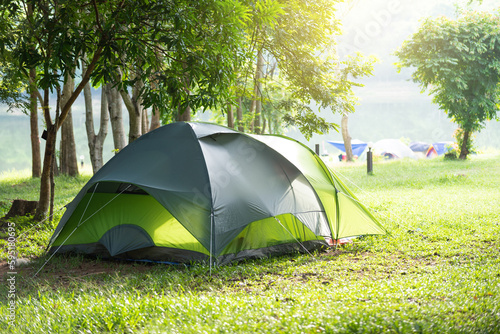 Green camping tent on the lawn in the national park on a relaxing holiday